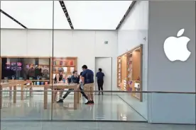  ??  ?? March 14 file photo Apple employees work inside a closed Apple store in Miami. Apple is temporaril­y closing 11 stores in Arizona, Florida, North Carolina and South Carolina just few weeks after reopening them in hopes that consumers would be able to shop in them without raising the risk of infecting them or company workers with the novel coronaviru­s that caused COVID-19.