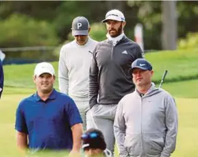  ?? AFP PIC ?? Dustin Johnson (second from right) and Patrick Reed (left) walk with their group during a practice round on Tuesday prior to the US
Open Championsh­ip.