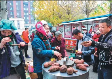  ?? JIANG MENG / CHINA DAILY ?? Keyana Nozzari Varkani sells sweet potatoes from a poverty stricken county at a market in Shenyang, Liaoning province, on Nov 2.