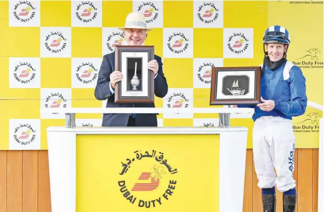  ??  ?? ↑
Trainer Marcus Tegening and jockey Jim Crowley receive the trophies for the Dubai Duty Free Mill Reef Stakes.