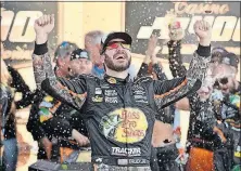  ?? [THE ASSOCIATED PRESS FILE PHOTO] ?? Martin Truex Jr. celebrates in victory lane after winning a Cup Series race at Kansas Speedway.