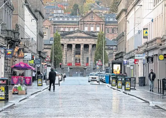  ??  ?? HARD TIMES: Quiet streets and struggling businesses in Dundee as the city is warned it could face even more stringent restrictio­ns.