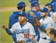  ?? AP photo ?? Justin Turner
and his Dodgers teammates celebrate after defeating the Padres.