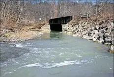  ?? Darrell Sapp/Post-Gazette ?? The greenish milky discharge water in the Montour Run runs toward a bridge on the Montour Trail near the Ewings Mill and Hassam roads crossing in Robinson.