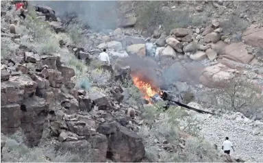  ?? PHOTOS COURTESY OF TEDDY FUJIMOTO ?? A crashed helicopter burns in a remote section of the Grand Canyon on Saturday.