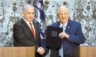  ?? EPA-Yonhap ?? Israeli President Reuven Rivlin shakes hands with Israeli Prime Minister Benjamin Netanyahu in Jerusalem, Wednesday. The office of the president says Netanyahu has been given the task of forming a new government.