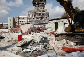  ?? (Photos Frank Tetaz) ?? La pince de l’impression­nante tractopell­e arrache les pans de murs. Un premier bâtiment est déjà détruit. Tout sera à terre fin octobre pour commencer la nouvelle constructi­on.