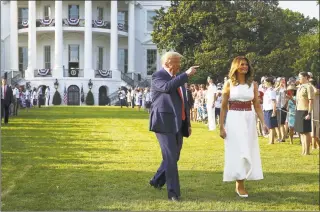  ?? Tasos Katopodis / Getty Images ?? President Donald Trump and first lady Melania Trump walk out to an event on the South Lawn of the White House on Saturday in Washington.