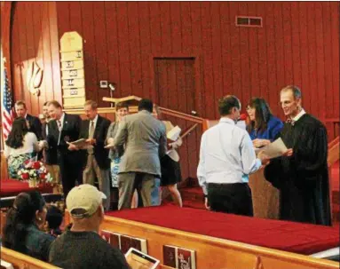  ?? TAWANA ROBERTS — THE NEWS-HERALD ?? U.S. District Court Magistrate Judge William Baughman presents the new U.S. citizens with Certificat­es of Naturaliza­tion on July 7.