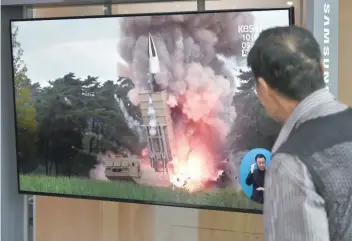  ?? — AFP ?? A man watches a television news screen showing file footage of a North Korean missile launch, at a railway station in Seoul.