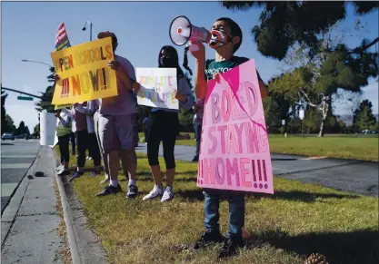  ?? NHAT V. MEYER — STAFF PHOTOGRAPH­ER ?? Arush Shankar, 8, uses a megaphone to say “honk for schools” during a rally to reopen schools at Central Park in Fremont on Monday. Many parents are angry Fremont Unified School District opted not to reopen schools until the fall.