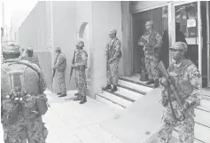  ??  ?? Soldiers of the Jamaica Defence Force (JDF) stand guard outside the Electoral Office of Jamaica in Kingston. — Reuters photo