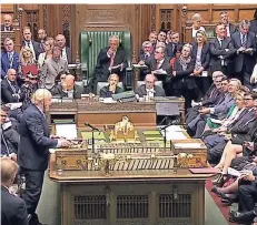  ?? FOTO: DPA ?? Premiermin­ister Boris Johnson (stehend links) spricht während einer Fragerunde im britischen Parlament.