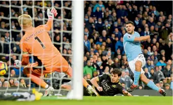  ?? — AFP ?? Manchester City’s Sergio Aguero scores in their English Premier League match against Leicester City at the Etihad Stadium in Manchester on Saturday. Man City won 5-1.