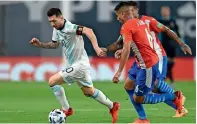  ??  ?? Lionel messi (left) dribbles past Paraguay’s Junior alonso. — AFP