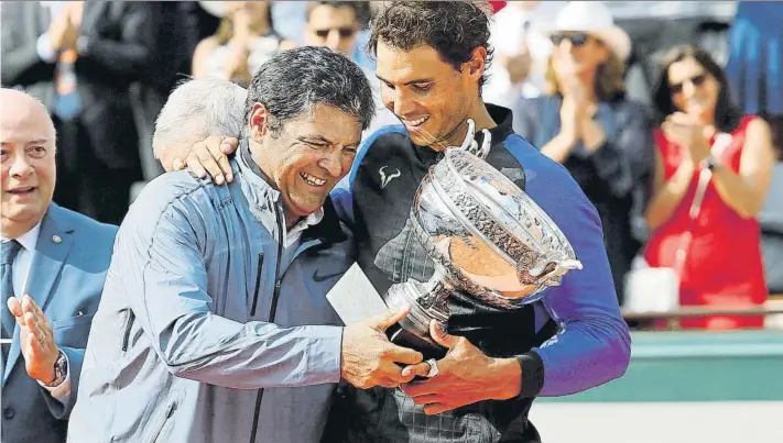  ?? FOTO: ALFONSO JIMÉNEZ ?? Un emocionado Toni Nadal entrega la décima Copa de Mosquetero­s a su pupilo y sobrino Rafa en la central de Roland Garros. El último episodio de una relación única en París, con Carlos Moyà y Francis Roig también en la grada