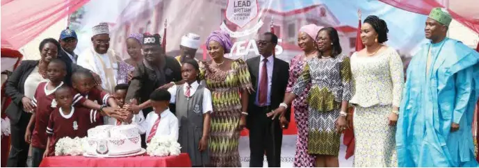  ??  ?? Founder of Lead British Internatio­nal School, Abuja, Hon. Wole Oke, flanked by students and parents, cutting the school's 10th anniversar­y cake