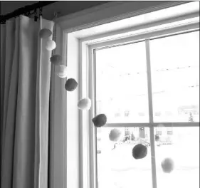  ??  ?? She knotted the ends of the thread into little loops and hung them on the curtain clips in her living room.