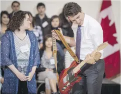  ?? MATT SMITH / THE CANADIAN PRESS FILES ?? Kristin Albert presents Justin Trudeau with a guitar built by students when the prime minister visited Oskayak High School in Saskatoon in April.