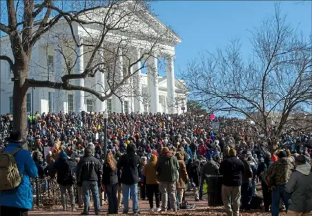  ?? Roberto Schmidt/AFP via Getty Images ?? Several thousand gun rights supporters massed Monday on the grounds of the Virginia Capitol in Richmond, Va., for a rally under heavy surveillan­ce and a state of emergency declared by authoritie­s fearing violence by far-right groups. Dressed in hunting jackets and caps, rallygoers were checked for weapons as they passed through tight security before entering a fenced-off area of Richmond’s Capitol Square for the so-called Lobby Day event.