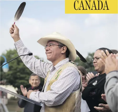  ?? DARRYL DYCK / THE CANADIAN PRESS ?? Coldwater Indian band Chief Lee Spahan raises an eagle feather in Vancouver after responding to a Federal Court of Appeal ruling Thursday that stalled the Trans Mountain Pipeline expansion.