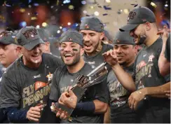  ?? Associated Press ?? Houston Astros' Jose Altuve holds up the championsh­ip trophy after Game 7 of baseball's American League Championsh­ip Series against the New York Yankees Saturday in Houston. The Astros won, 4-0, to win the series.