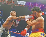  ?? JOHN LOCHER/ASSOCIATED PRESS FILE PHOTO ?? Floyd Mayweather Jr. punches Manny Pacquiao during their 2015 fight. Mayweather says he will again fight Pacquiao.