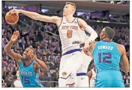  ??  ?? BLOCK AND KEY: Kristaps Porzingis blocks Kemba Walker during the fourth quarter of the Knicks’ 118-113 win over the Hornets.