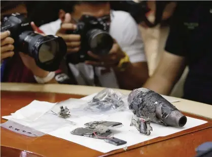  ??  ?? MANILA: Photograph­ers take pictures of an 81mm mortar shell which was detonated after it was found inside a suspicious package near the US Embassy in Manila, Philippine­s yesterday. —AP