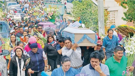  ??  ?? Tras ser velados en la explanada municipal de Santa María Ecatepec, familiares y amigos acompañaro­n al panteón el cortejo fúnebre de 12 de las 13 víctimas.