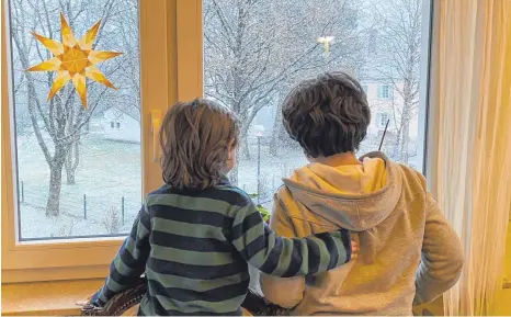  ?? FOTOS: REINER SCHICK ?? Blick in die Freiheit: Die beiden Kinder schauen sehnsuchts­voll aus dem Fenster und staunen über das Aprilwette­r im März.