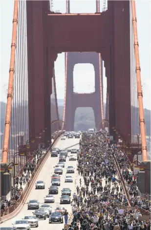  ?? Jessica Christian / The Chronicle ?? Thousands of people take part in a march across the Golden Gate Bridge, spilling into traffic lanes and eventually forcing the temporary closure of the span.