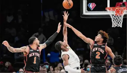  ?? Sue Ogrocki / Associated Press ?? Thunder guard Shai Gilgeous-alexander shoots between Knicks forward Obi Toppin (1) and guard Miles Mcbride in the first half on Friday night. Gilgeous-alexander returned from an ankle injury to score 23 points.