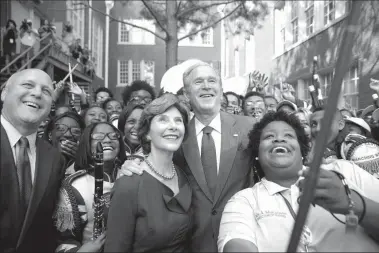  ??  ?? TOP: Former President George W. Bush poses for a ‘selfie’ with former first lady Laura Bush, marching band director Asia Muhaimin, right, and New Orleans Mayor Mitch Landrieu, far left, Friday at Warren Easton Charter High School in New Orleans.