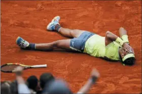  ?? JEAN-FRANCOIS BADIAS — THE ASSOCIATED PRESS ?? Spain’s Rafael Nadal celebrates his record 12th French Open tennis tournament title after winning his men’s final match against Austria’s Dominic Thiem in four sets, 6-3, 5-7, 6-1, 6-1, at the Roland Garros stadium in Paris, Sunday.