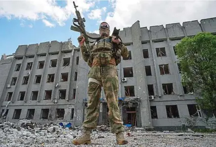  ?? A. Galperin / Sputnik / Sipa ?? Un soldat russe pose fièrement devant un immeuble détruit par les bombes, dans la ville assiégée de Popasna, dans l’est du Donbass.