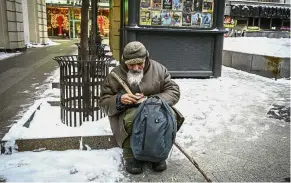  ?? — AFP ?? Making do: An elderly man eating a snack as he sits on a street in central Moscow. The elderly people are particular­ly hard hit by the economic strains in Russia.