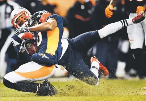  ??  ?? Broncos wide receiver Emmanuel Sanders gets tackled by New England Patriots cornerback Malcolm Butler during the fourth quarter Sunday at Sports Authority Field at Mile High. Sanders finished with three receptions for 48 yards. Helen H. Richardson, The...