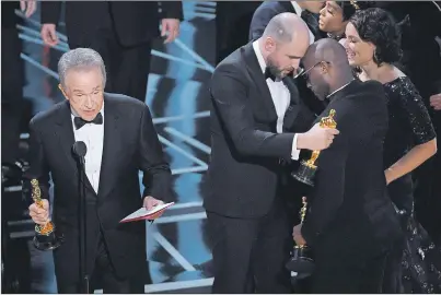  ?? AP PHOTO ?? Warren Beatty, from left, reveals “Moonlight” as the actual winner of best picture as Jordan Horowitz embraces Barry Jenkins at the Oscars on Sunday at the Dolby Theatre in Los Angeles.