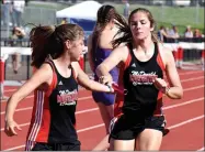  ??  ?? Cassadi Dowd (left) takes a handoff from Adyson Sanny in the 4x800 relay at the Big 8 Conference Track and Field Championsh­ips held May 7 at MCHS. The Lady Mustangs’ relay took second place in the race.