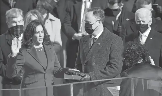  ??  ?? Vice President Kamala Harris is sworn in while her husband, Doug Emhoff, holds the Bible at the U.S. Capitol in Washington. Harris chose to be sworn in by Supreme Court Associate Justice Sonia Sotomayor, the first Latina justice on the high court.