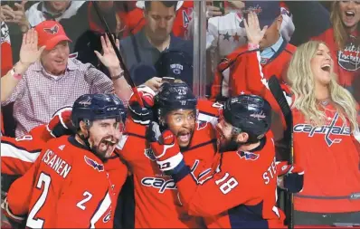  ?? PABLO MARTINEZ MONSIVAIS / AP ?? An ecstatic Devante Smith-Pelly (center) is mobbed by his Washington Capitals teammates after scoring against the Vegas Golden Knights in Game 3 of the NHL Stanley Cup Final on Saturday in Washington. The Capitals won 3-1 to take a 2-1 series lead.