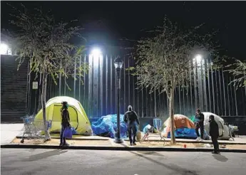  ?? NELVIN C. CEPEDA U-T ?? Volunteers check tents in the East Village on Jan. 26 as part of the annual count of homeless individual­s.