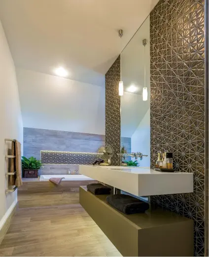  ??  ?? THIS PAGE As well as task and ambient light, your lighting can accentuate the design of your room, says designer Celia Visser; here it highlights the textured tile. OPPOSITE Well designed task lighting is vital in a bathroom, as designed by Celia.