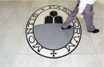  ?? — Reuters ?? A man walks on a logo of the Monte dei Paschi di Siena bank in Rome, Italy.