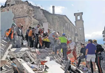  ?? ALESSANDRA TARANTINO, AP ?? Rescuers carry a stretcher following an earthquake in Amatrice, central Italy, on Wednesday. At least 73 people were killed in the quake though that number is expected to rise.