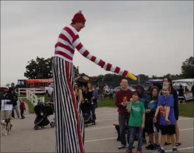  ?? ANDREA GRABENSTEI­N — FOR DIGITAL FIRST MEDIA ?? A performer on stilts delights a group of children at East Norriton’s 40th annual Community Day celebratio­n, Saturday at Standbridg­e Street Park.