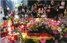  ?? Foto: Jan Woitas, dpa ?? Zwei Tage nach der tödlichen Messeratta­cke: Menschen haben am Tatort in der Chemnitzer Innenstadt Blumen und Kerzen niedergele­gt.