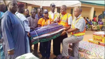  ??  ?? Officials of NEMA handing over the materials to representa­tives of the two affected villages