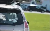  ?? Justin Sullivan Getty Images ?? A CAR displaying tags for ride-sharing companies Uber and Lyft operates in San Francisco in March.